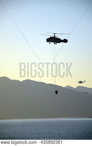 Russian KA-32 helicopter draws water from the sea to extinguish a forest fire. 30 July, 2021. Marmaris,Turkey