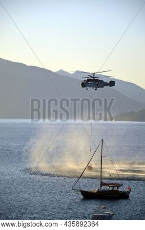 Russian KA-32 helicopter draws water from the sea to extinguish a forest fire. 30 July, 2021. Marmaris,Turkey