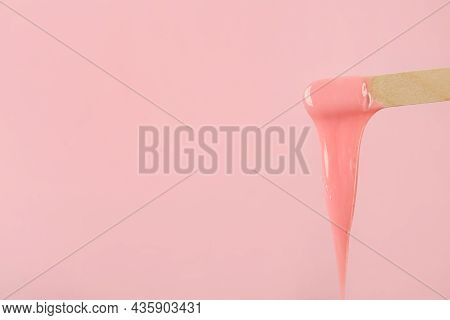 Wooden Spatula With Hot Depilatory Wax On Pink Background. Space For Text