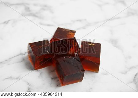 Heap Of Delicious Grass Jelly Cubes On White Marble Table, Closeup
