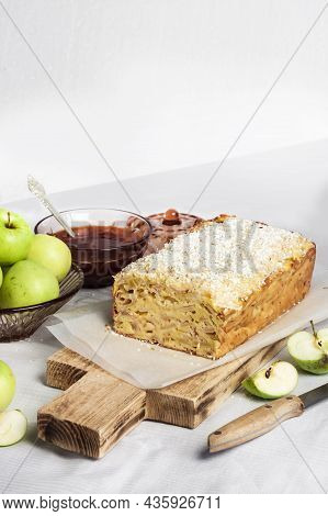 Apple And Coconut Oaf Cake On Wooden Cutting Board And Apples In A Vase. Copy Space