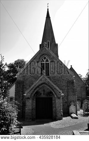 An Exterior View Of The Stone Church Building In The Town Of Grouville On The Island Of Jersey.