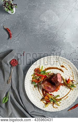 Roasted Beef fillet with vegetables. Roasted Mignon steak with paprika and celery. Beef tenderloin with garnish. Beef steak medium rare doneness. Delicious meat menu. Dish concept with angus beef