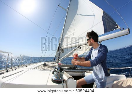 Man sailing with sails out on a sunny day