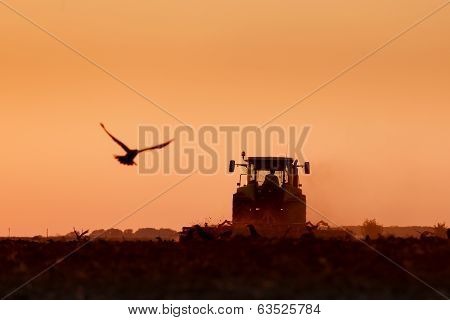 Tractor plowing in dust