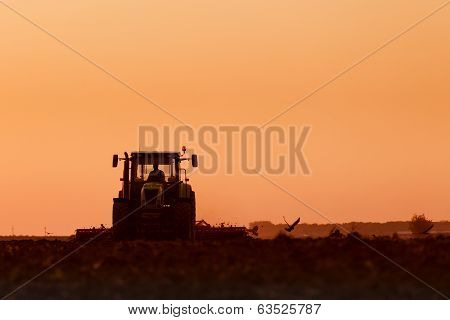Tractor plowing in dust
