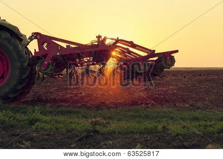 Tractor plowing in dust