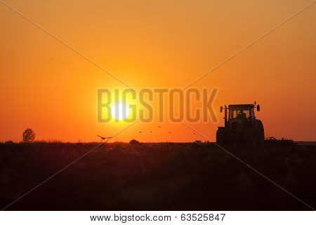 Tractor plowing in dust