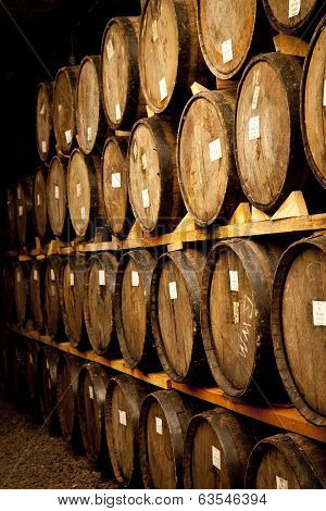 Wine barrels stacked in the old cellar of the winery.