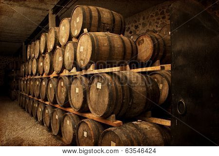 Wine barrels stacked in the old cellar of the winery.