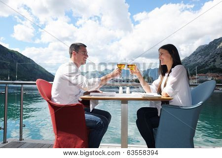 happy young couple having lanch at beautiful restaurant on the beach