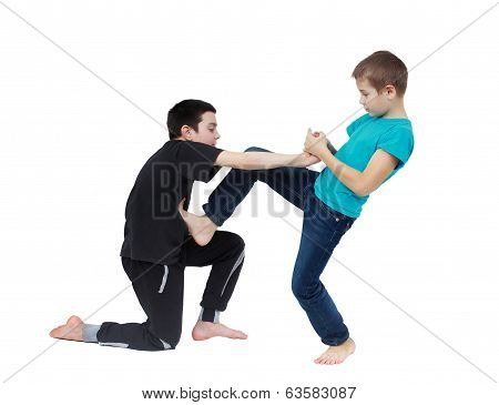 In the blue T-shirt boy is doing armlock on a boy in a black T-shirt