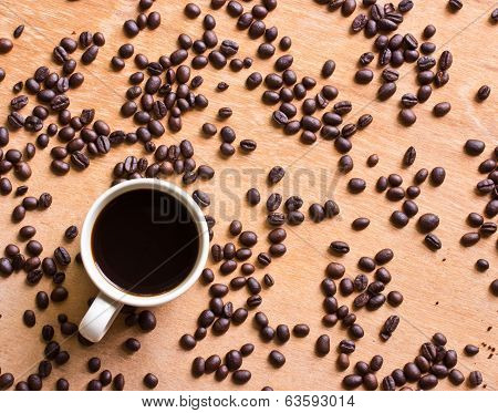 Cup Of Black Coffee And Coffee Beans On Wooden Background.