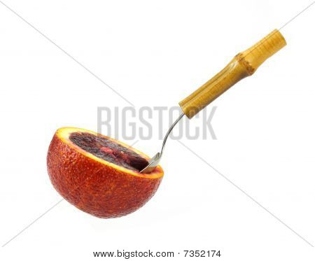 Arancia sanguigna con cucchiaio frutta