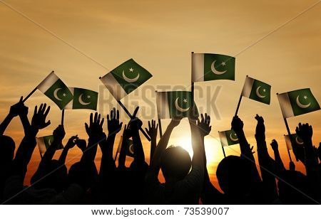 Group of People Waving Flag of Pakistan in Back Lit