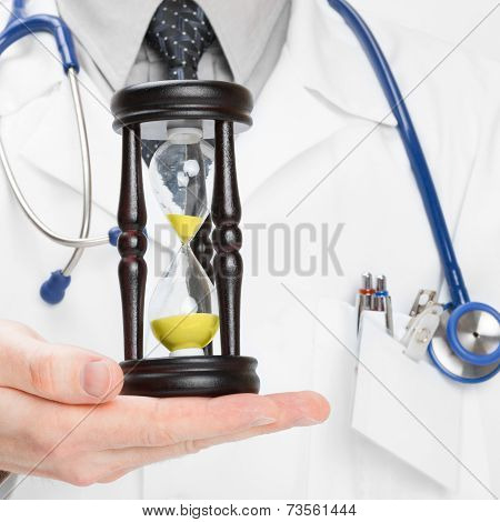 Doctor Holdling In His Hand A Hourglass - Heath Care Concept