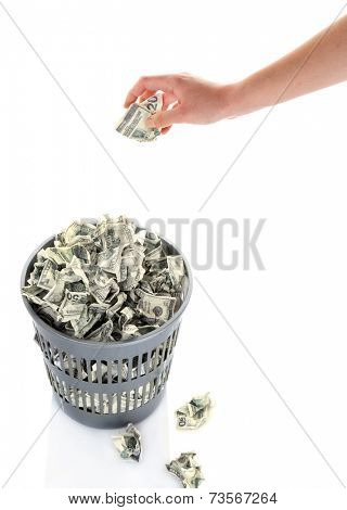 Hand throwing money into trash can isolated on white