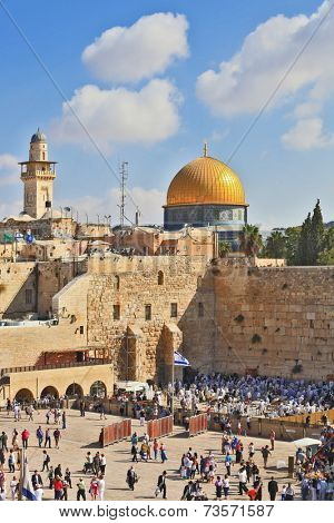 JERUSALEM, ISRAEL - SEPTEMBER 18, 2013:  Prayer at the Kotel. Religious Jews in white prayer shawls are going to pray at the Western Wall of the Temple. Sunny morning in the holiday of Sukkot