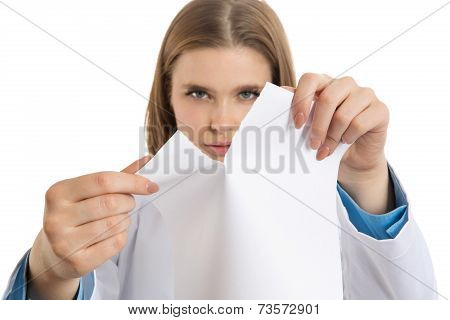 Frustrated young female doctor tearing paper