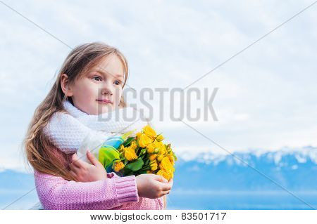 Little girl with yellow roses