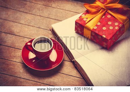 Cup Of Coffee And Gift Box With Book On A Wooden Table