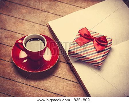 Cup Of Coffee And Gift Box With Book On A Wooden Table