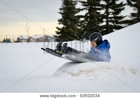 Winter Fun - Child Sledding/Tobogganing Fast Over Snow Ramp