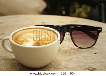 Coffee With Sunglasses On Background Of Wooden.