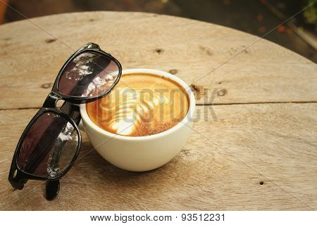 Coffee With Sunglasses On Background Of Wooden.