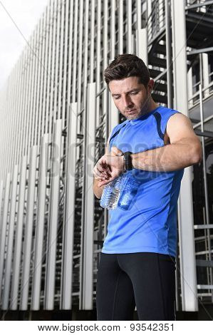 Young Sport Man Checking Time On Chrono Timer Runners Watch Holding Water Bottle After Training Sess