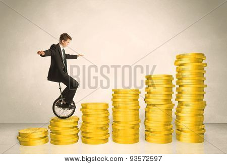 Business man riding monocycle up on coin graph concept on background