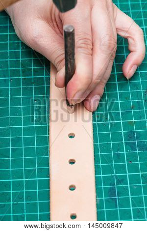 Punching Holes In New Belt With Hole Punch