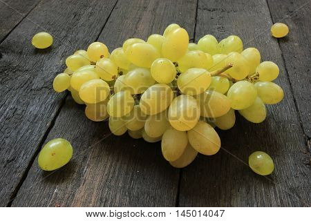 Fresh grapes on wooden background. Close up view of ripe green wine grape. View with fresh green grape.