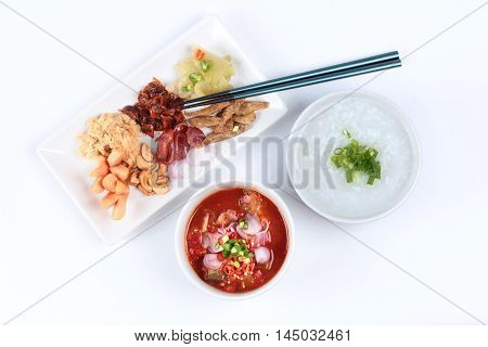Rice gruel and  side dish  on white background. (Dried shredded pork,Chinese sausage,crispy fish,sausage, fried baby clams,sliced red onion,pickle Chinese cabbage ,Spicy sardine salad and shallots )