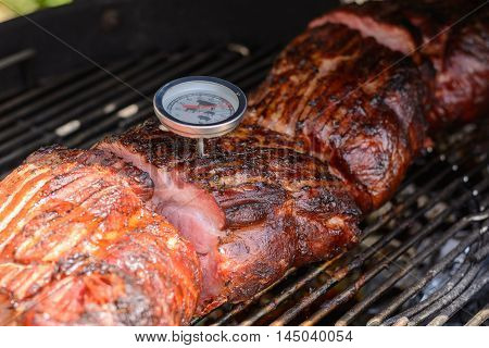 With thermometer meat temperature is checked at the kettle grill