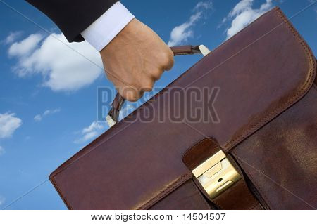 Hombre de negocios con su bolsa de trabajo sobre el cielo azul, símbolo de trabajo reclutamiento y oportunidad.