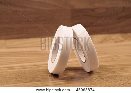Pair roll's of double sided tape on wooden background