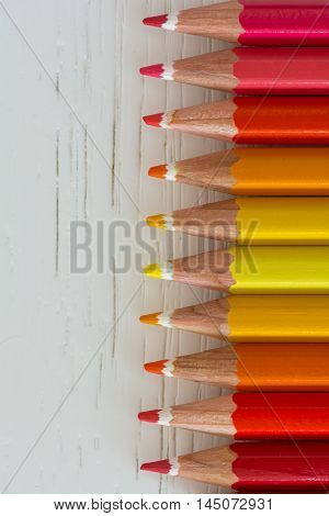 Sharp colorful crayons aligned on a white background