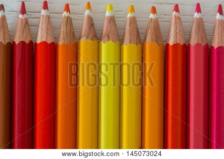 Sharp colorful crayons aligned on a white background
