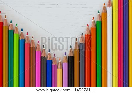 Sharp colorful crayons aligned on a white background