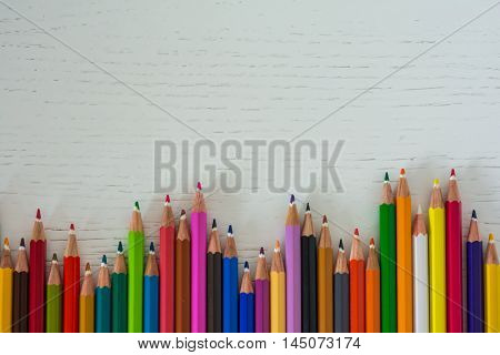 Sharp colorful crayons aligned on a white background