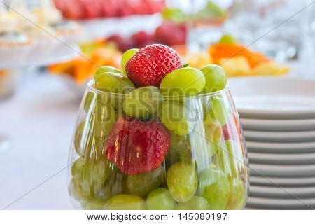Authentic buffet, assorted fresh fruits, berries and citrus fruits. Morning atmospheric lighting, fashionable trendy spot soft focus. Preparation for design creative menu.