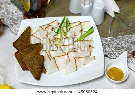 on a plate with greens and mustard