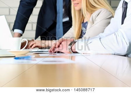 Business colleagues working and analyzing financial figures / graphs on a digital laptop