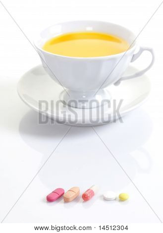 Prášky a tablety s šálkem čaje