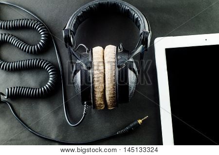 blank notebook in top view with music concept Black background headphones