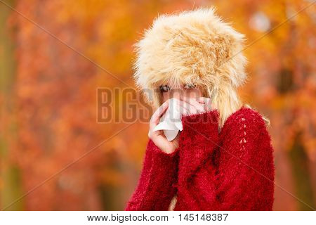 Sick Woman In Autumn Park Sneezing Into Tissue.