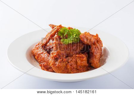 Korean style deep fried chicken wings mix with spicy barbecue sauce in ceramic dish