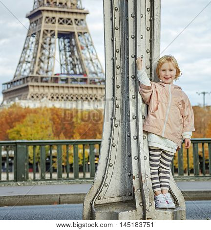 Year round fit & hip in Paris. Full length portrait of happy active child in sport style clothes against Eiffel tower in Paris