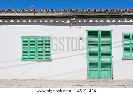 White Building With Green Shutters In El Terreno